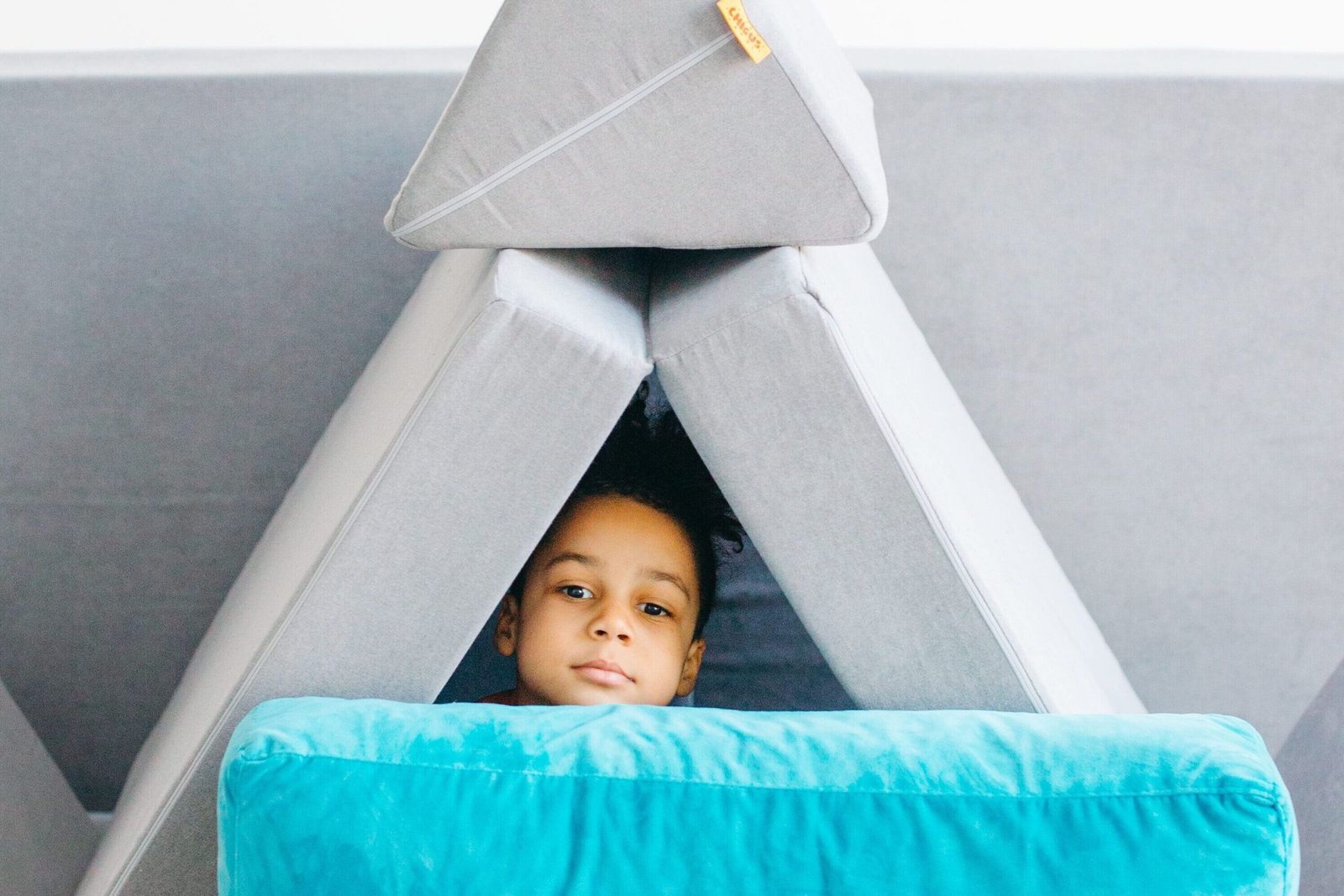 Preschoolers building a pillow fort indoors